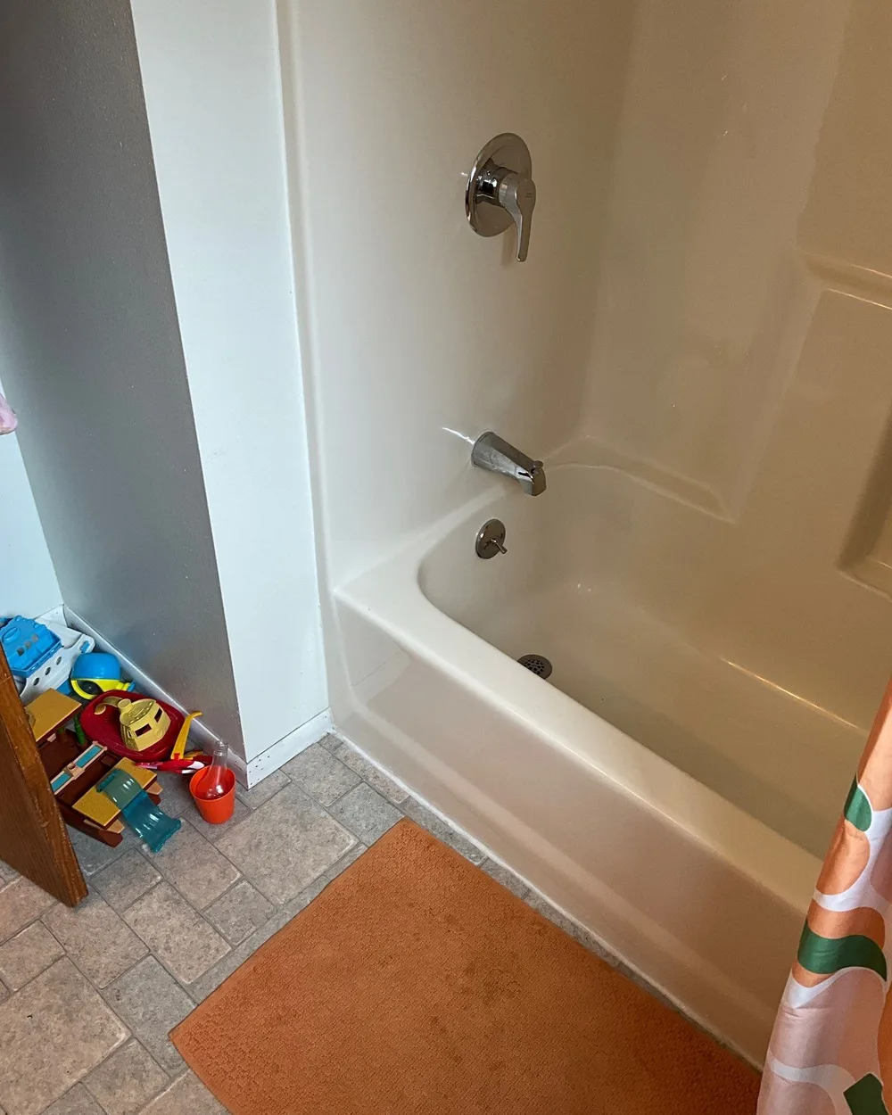 Dated alcove bathtub with chrome fixtures before remodel in Seattle